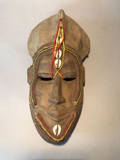 Carved wooden mask, coloured beads and cowries,...