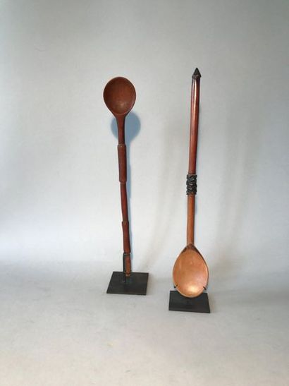Two long-handled carved wooden spoons. The...