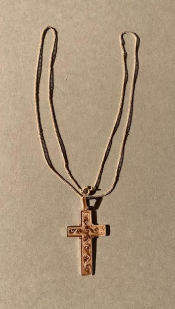 Croix en or jaune 14K (585), gravée de volutes.
On...