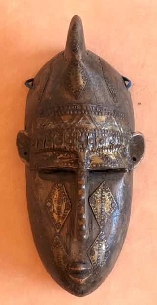Carved wooden mask applied with leaves and...