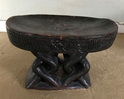 African stool made of carved wood with a...