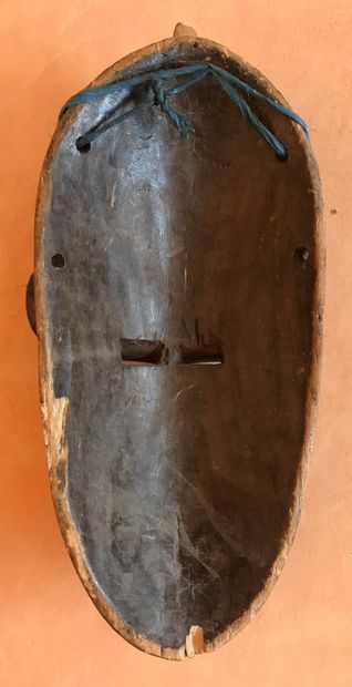 Carved wooden mask applied with leaves and...