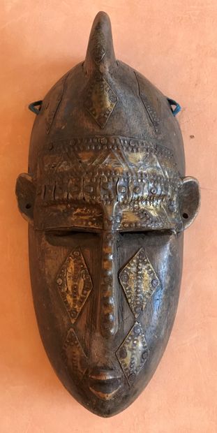 Carved wooden mask applied with leaves and...