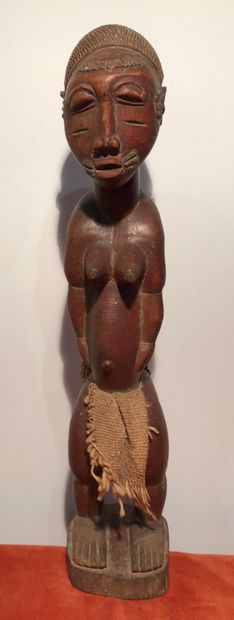 Statuette of a woman in carved wood, the...