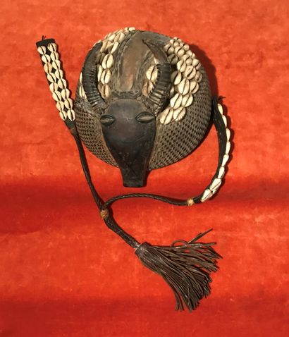 Headdress in calabash and leather featuring...
