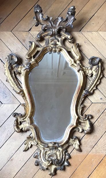 A gilded wood mirror with a contoured frame...