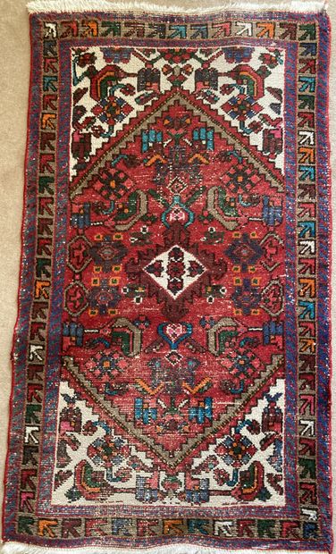 Small oriental carpet in wool with red background....