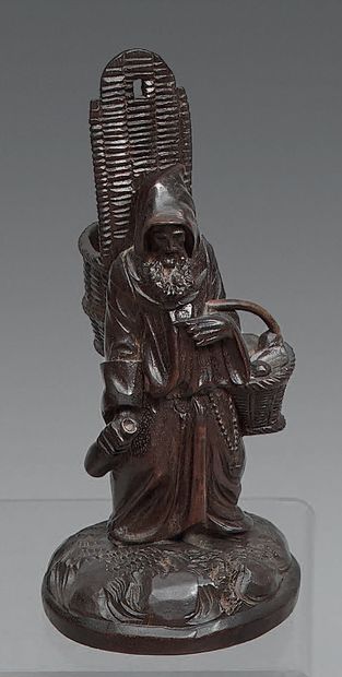 Statuette of a monk in carved wood, carrying...