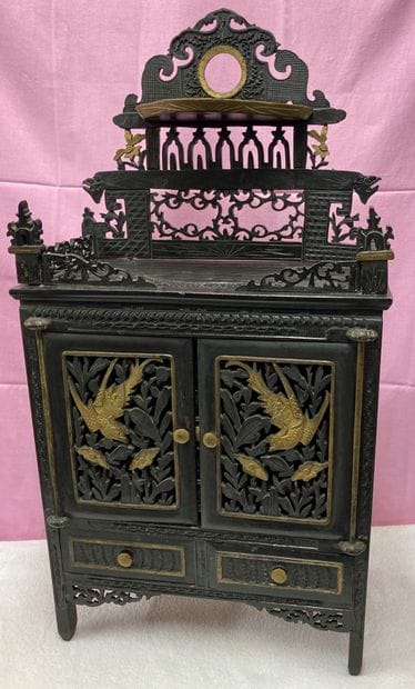
Small blackened wood cabinet enhanced with...