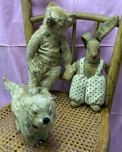 Three stuffed animals: a teddy bear, a dog...