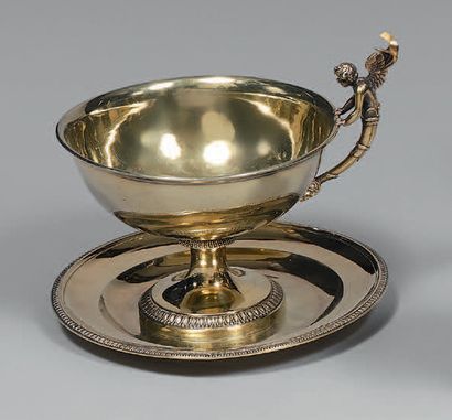 A gilt cup and saucer, the rims with water-leaf...