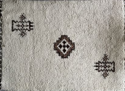 Rugs: a Moroccan carpet with a beige background,...