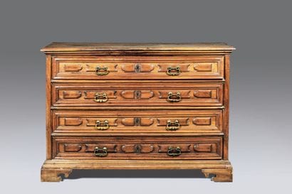 Chest of drawers in molded fruitwood. The...