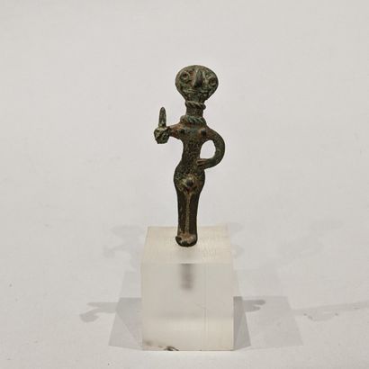 Stylized male votive statuette whose discoidal...