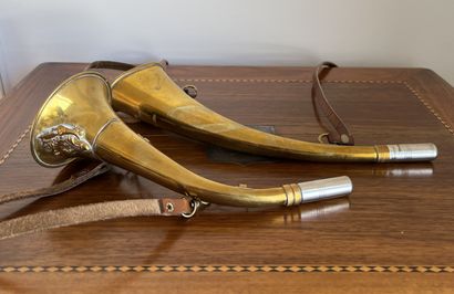 Two brass hunting horns, one decorated with...
