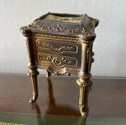 Metal box with golden patina representing...