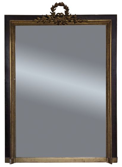 Miroir à entourage en bois patiné et doré,...