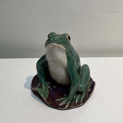 Green and yellow glazed ceramic frog on a...