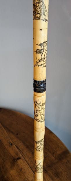 Bone cane engraved with scenes and characters...
