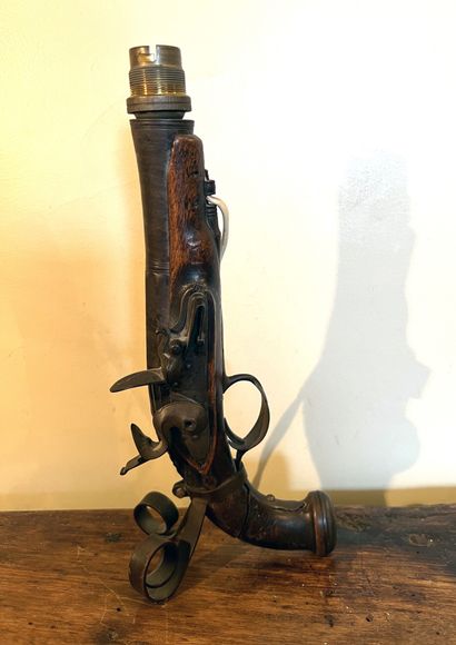 Old flintlock pistol mounted as a lamp. As...