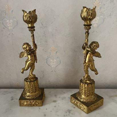 A pair of ormolu torches featuring torch-bearing...