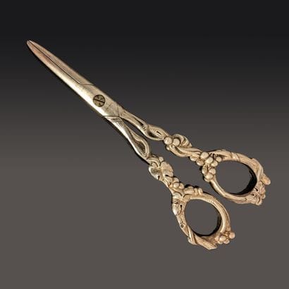 A pair of silver grape scissors chased with...