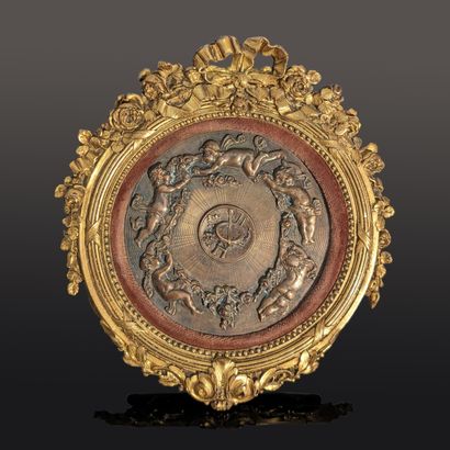 Round medallion in patinated brass, decorated...