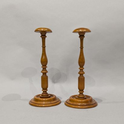 Two hat stands in varnished wood.