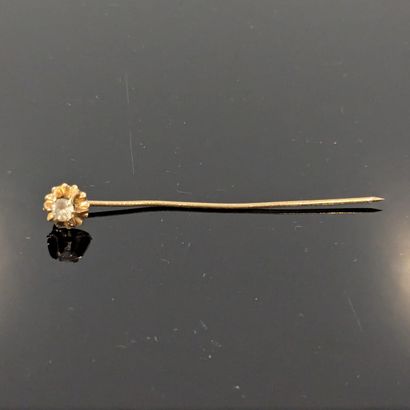 Yellow gold tie pin set with a white stone....