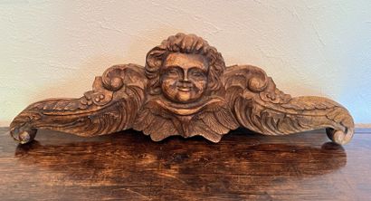 Carved wood element featuring an angel's...