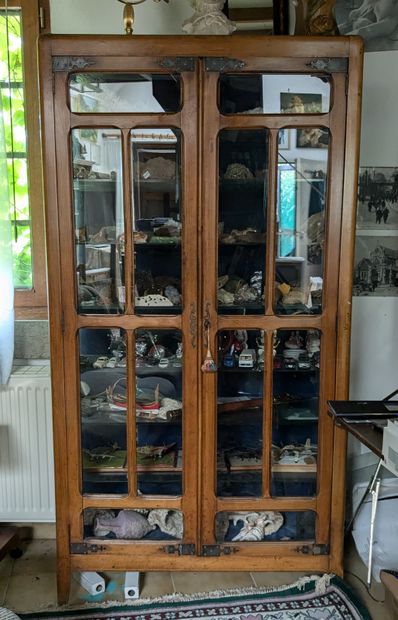 Vitrine en bois naturel. Ouvre par deux portes,...