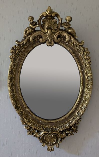 Miroir à entourage ovale en composition dorée...