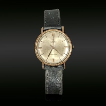 Montre d'homme en métal doré, le boîtier...