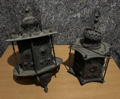 Two patinated metal lanterns adorned with...