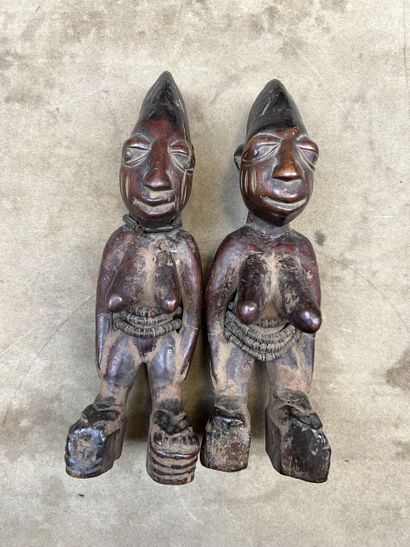 Pair of female Ibeji twins in patinated wood....