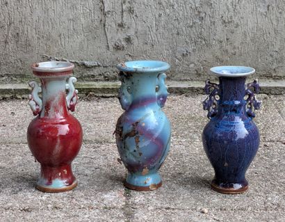 Three small baluster-shaped vases in oxblood,...