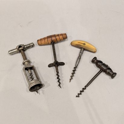 Four antique corkscrews, two with wooden...