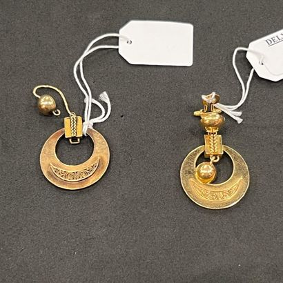 Deux boucles d'oreille de même modèle, une...