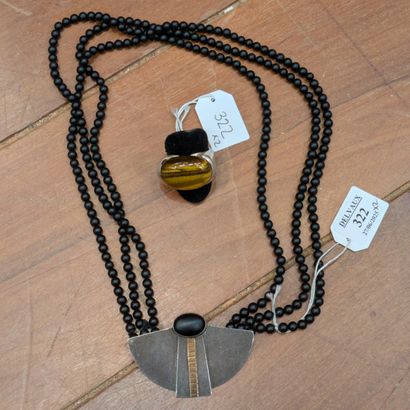 Triple-row jet pearl necklace holding a silver...
