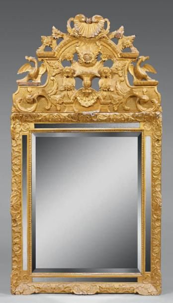 Miroir en bois doré, le fronton sculpté de...