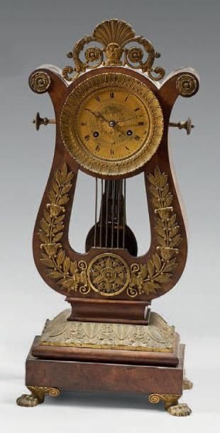Pendule lyre en placage d'acajou ornée de...