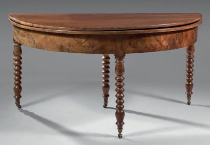 Large table demi-lune en noyer et noyer ronceux.
Elle...