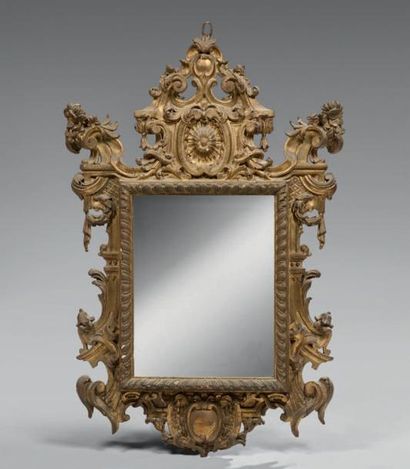 Miroir en écusson en bois doré, le fronton...