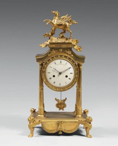 Pendule portique en bronze doré surmontée...