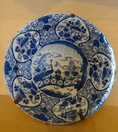 Grand plat rond en faïence à décor d'un paon...