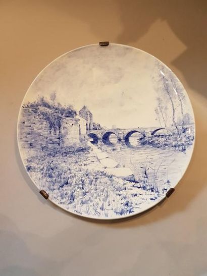 Grand plat rond en faïence à décor en camaïeu...