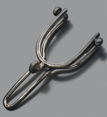Pince-à-billets en argent stylisé d'un éperon.
Signée...