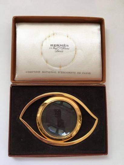 HERMES. Loupe en métal doré en forme d’œil,...