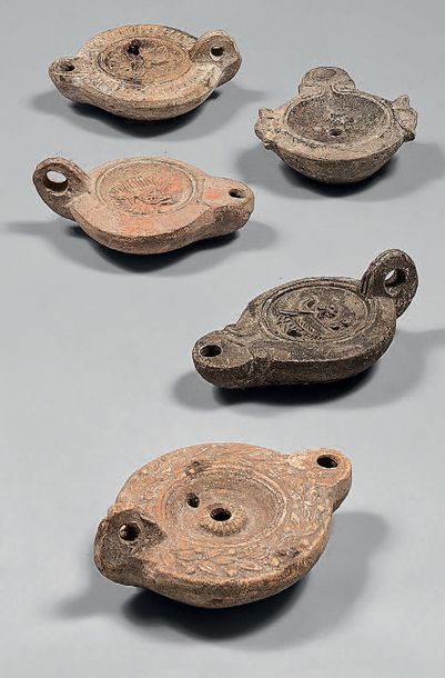 Cinq lampes à huile ornées d'un masque de...