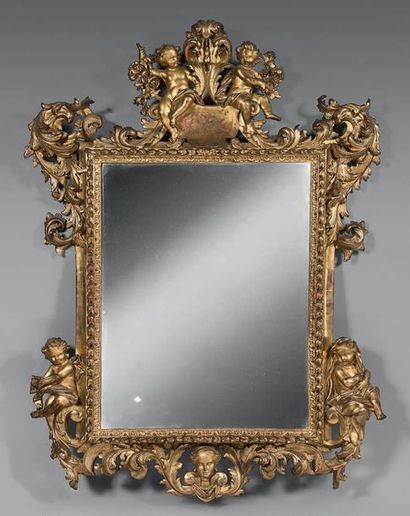 Miroir à entourage en bois doré à décor d'amours...